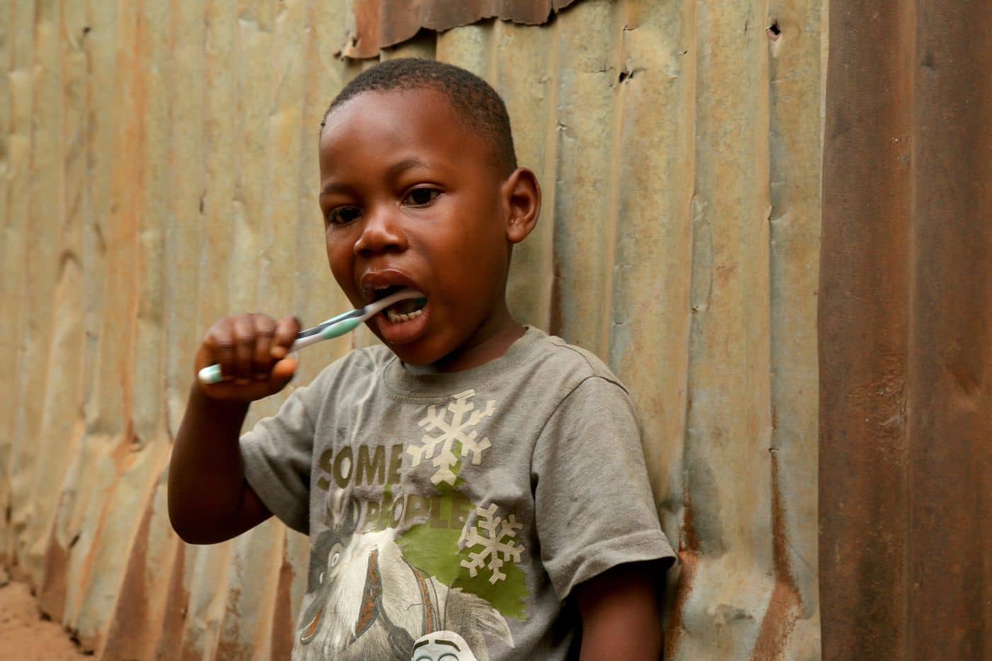 Boy brushing his teeth outdoors