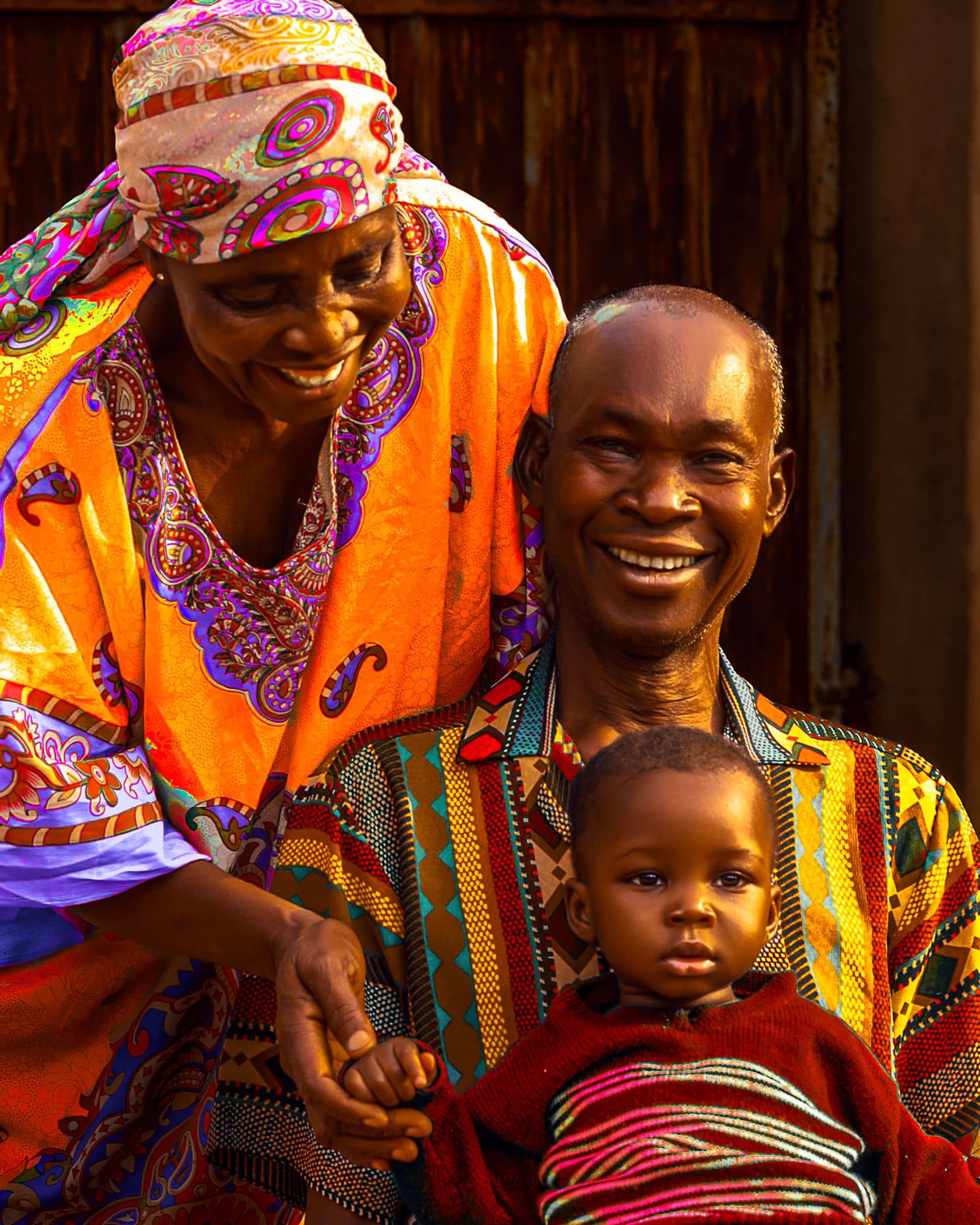 Grandparents in traditional clothing smiling with a grandchild