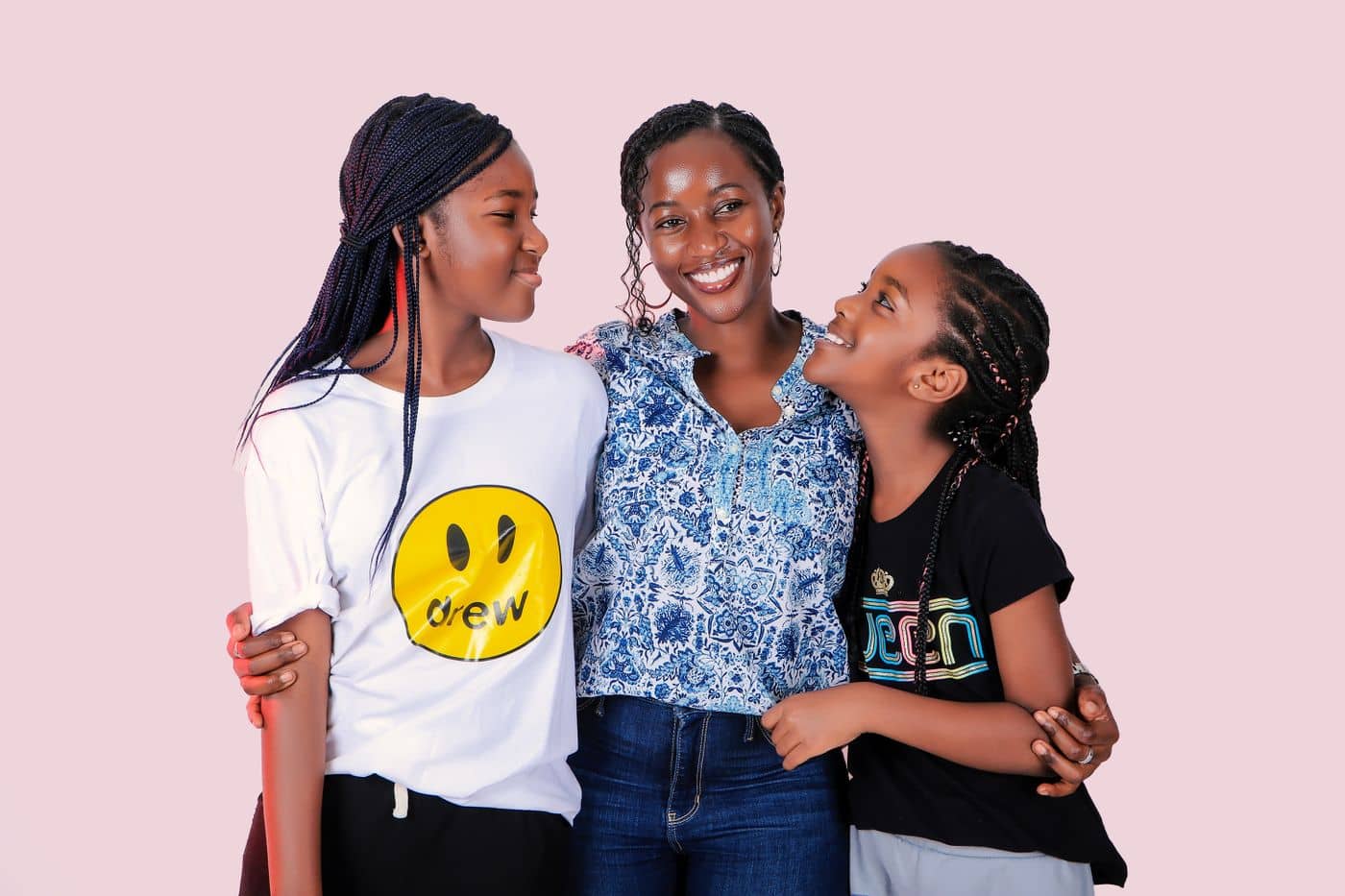 Mother hugging her two smiling daughters